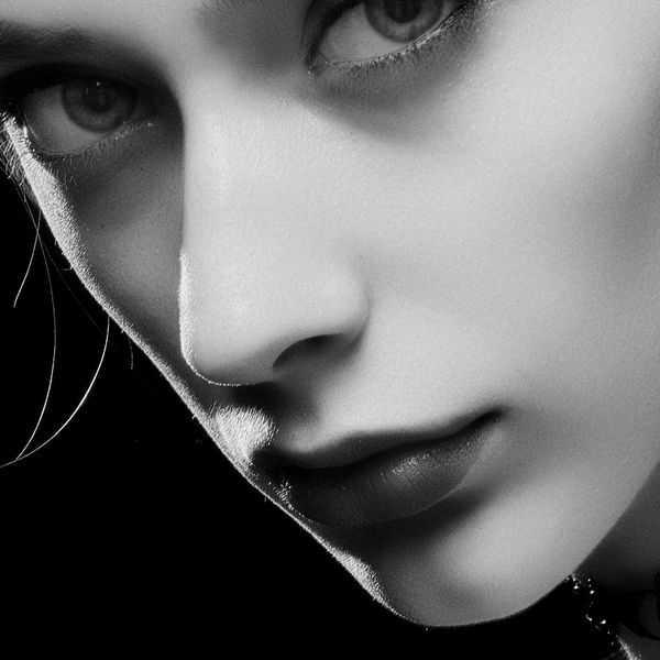 Close-up of a person's serene face with eyes closed, focusing on breathing.